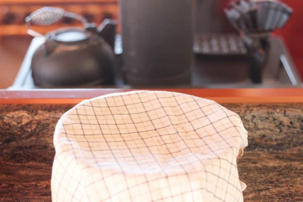 Bowl covered with tea towel on a counter