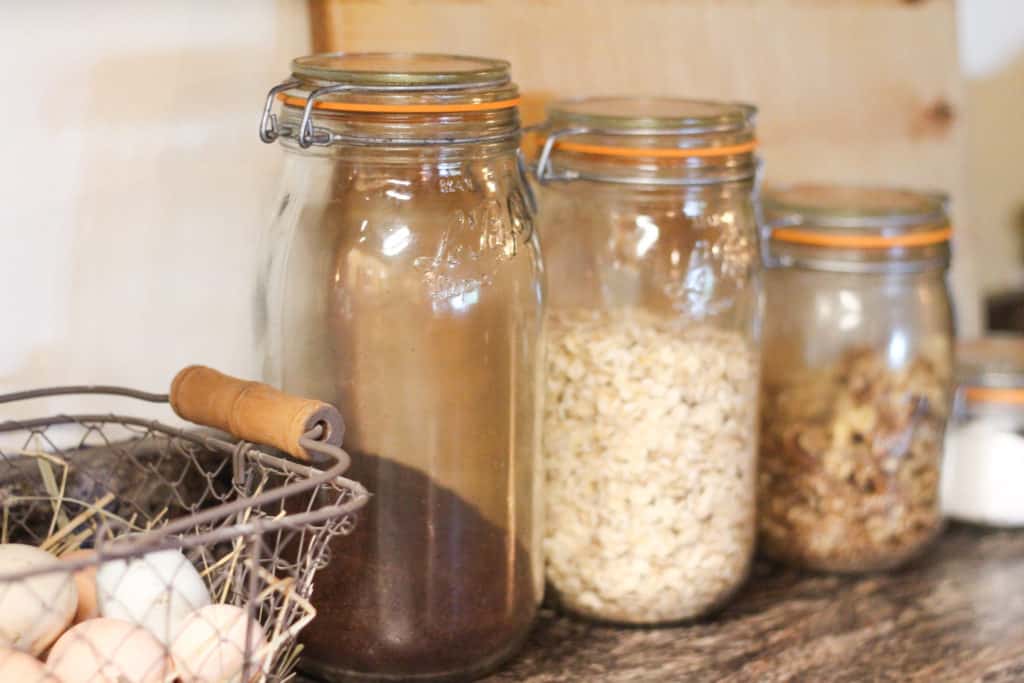 Four glass jars in a row with food. Log home kitchen essentials.