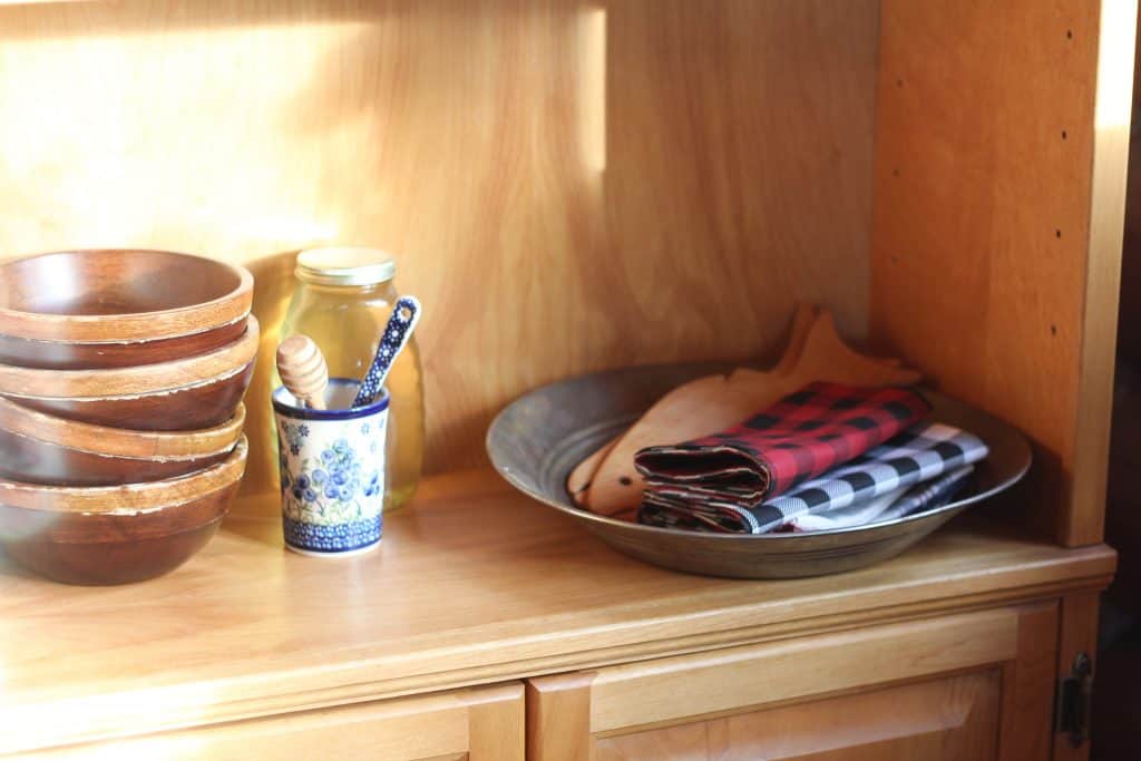 A decorated shelf with the cloth napkins laying on it