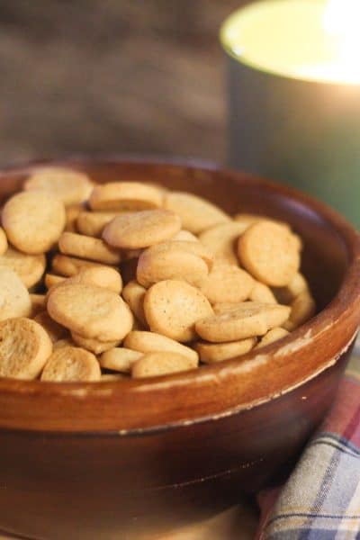 a bowl of pepper nut cookies by a candle