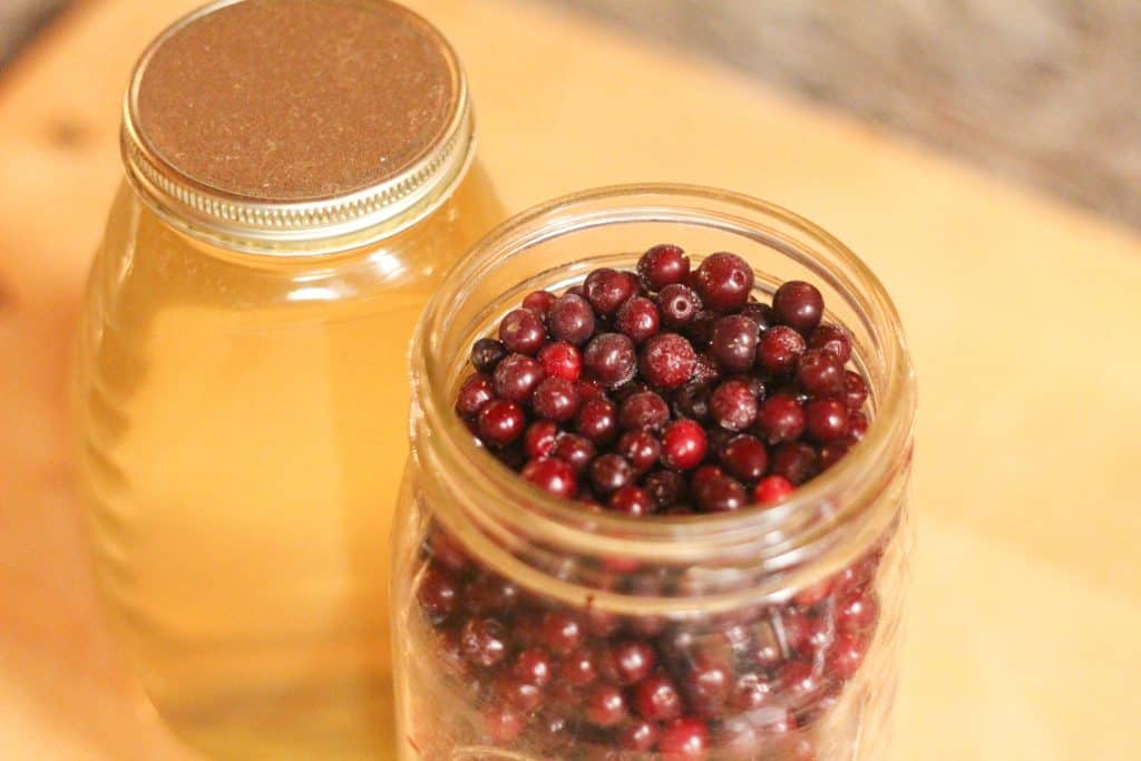 a jar of honey and a jar of frozen cranberries 