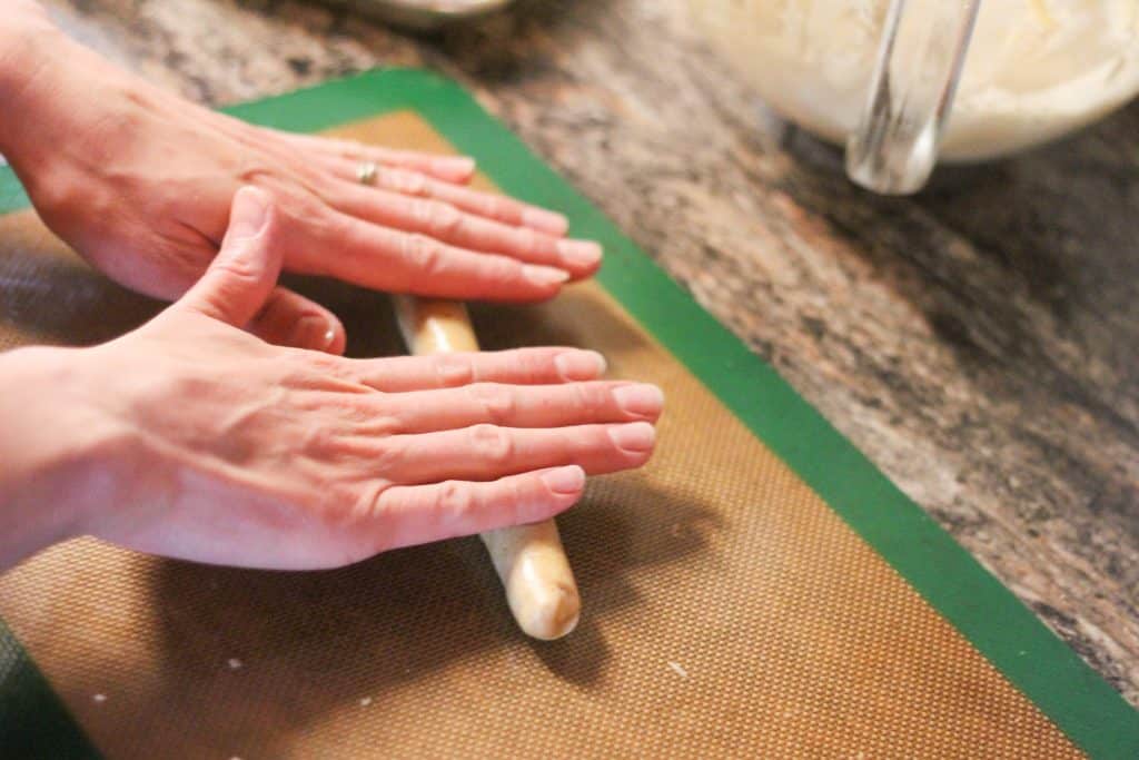 hands rolling out cookie dough
