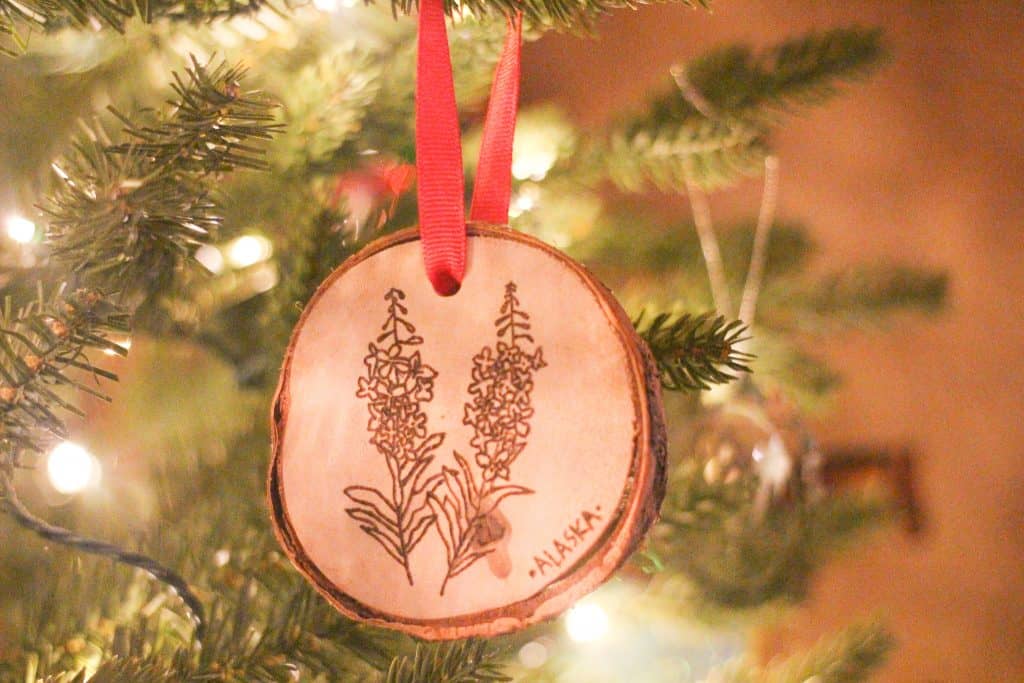 a wooden ornament with flowers wood burned onto it