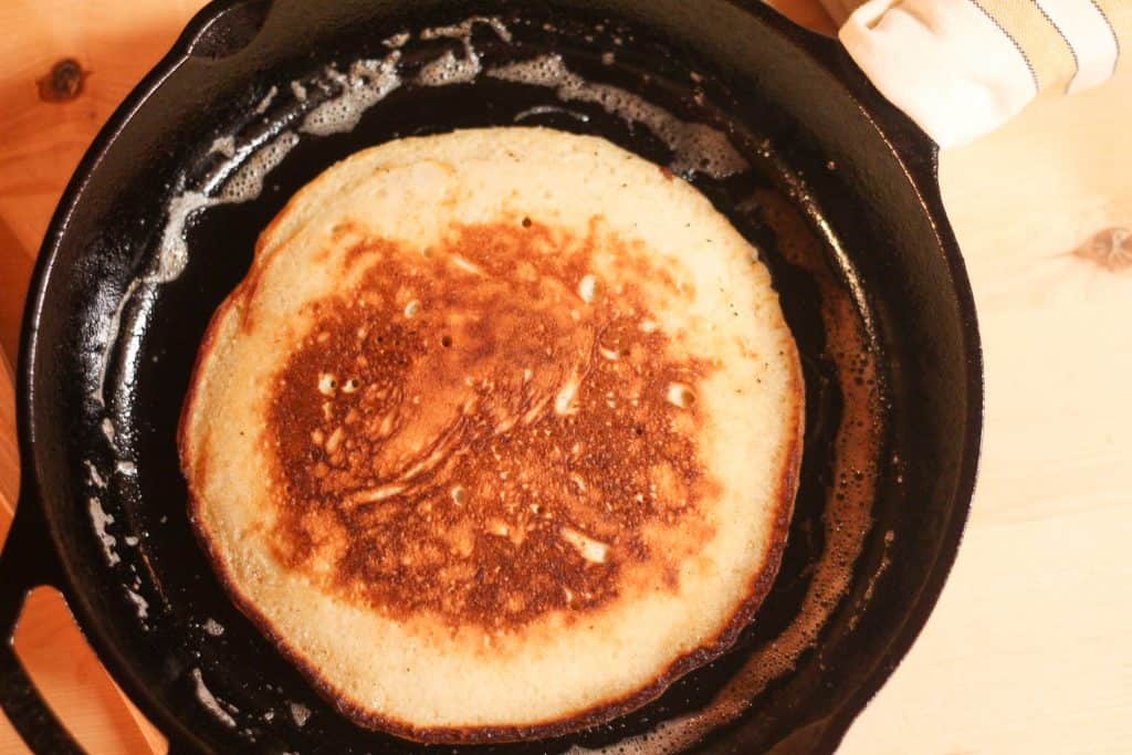 a pancake cooking in cast iron