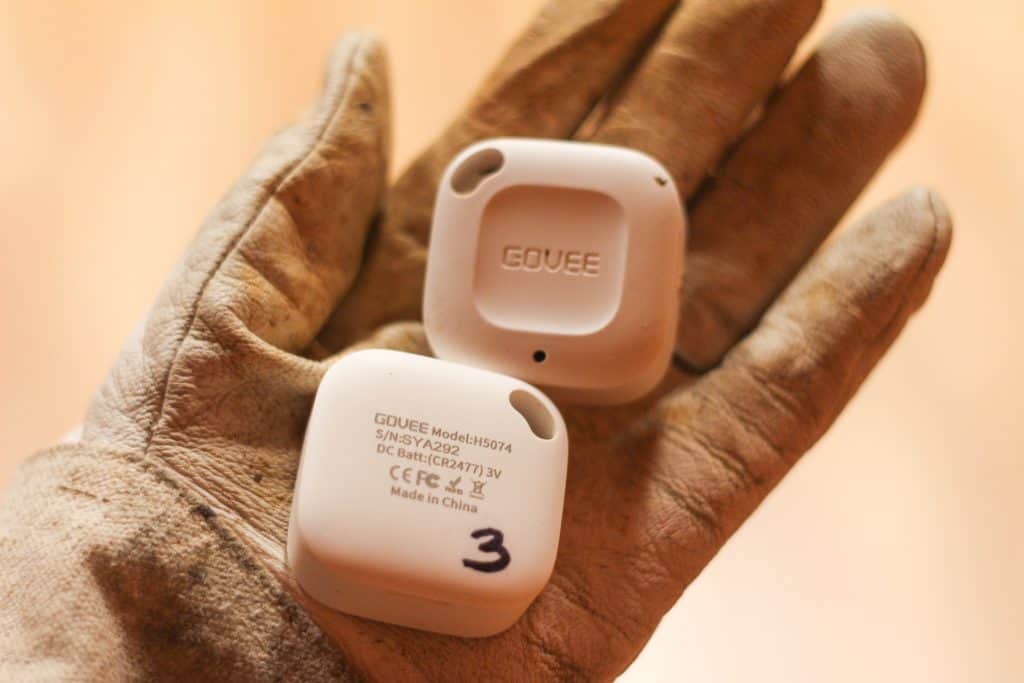 Hand holding two small electronic temperature pucks