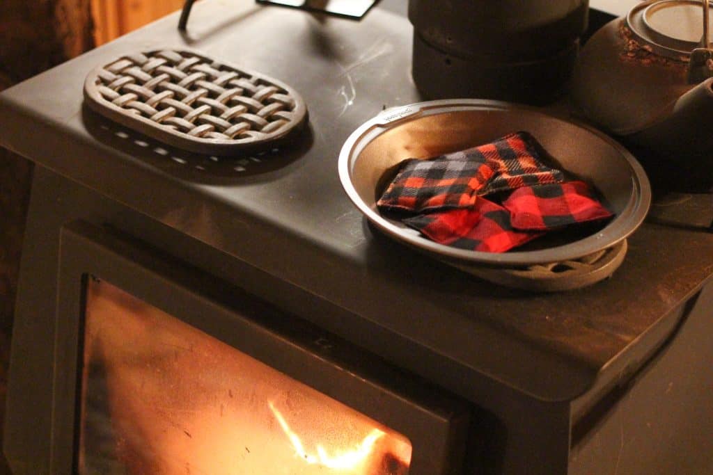 Homemade hand warmers in a metal pan on top of a wood stove