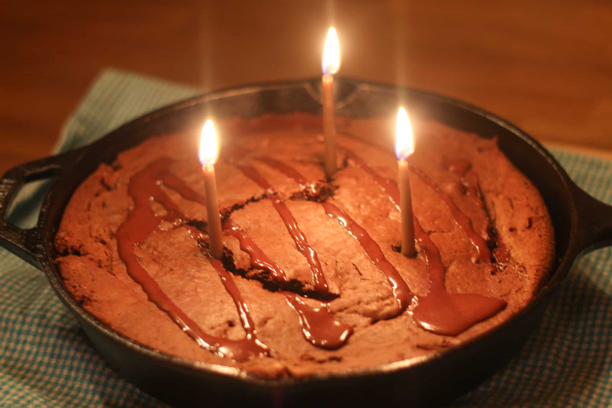 three birthday candles in a chocolate cake