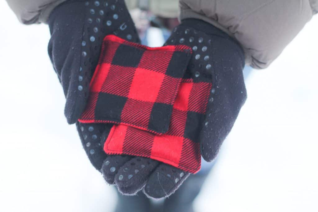 Hands wearing gloves holding a handmade hand warmer