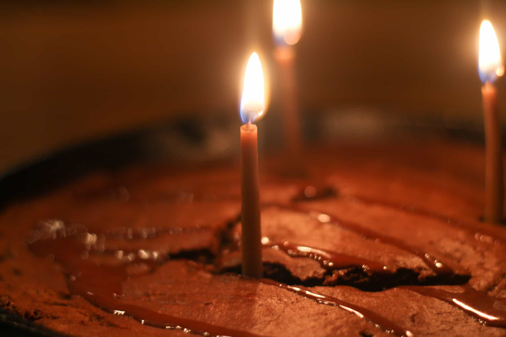 lit birthday candles in a chocolate cake