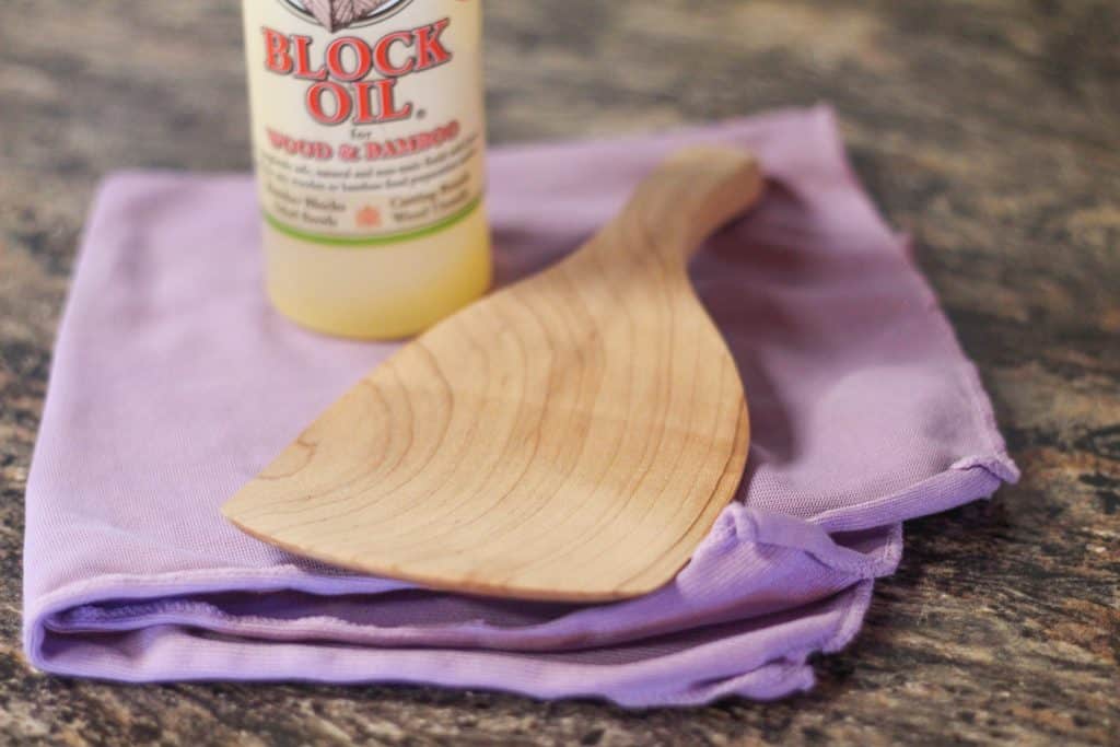 Purple rag with bottle of wood oil and a butter paddle