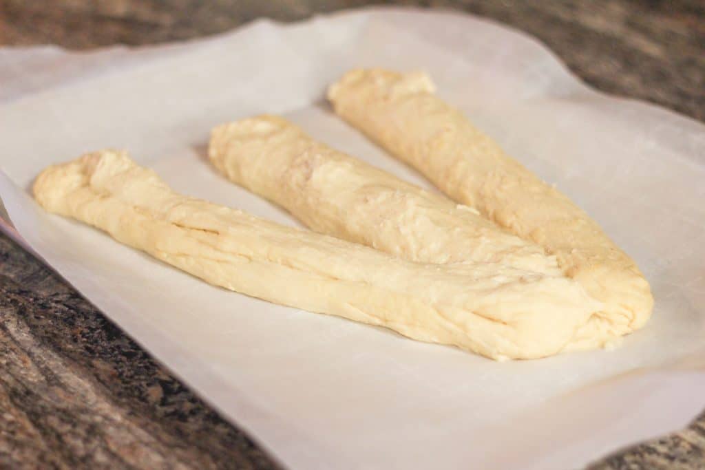 Three strips of dough laying on a cookie sheet