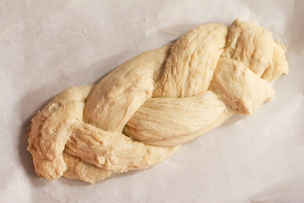 Raw bread dough braided on a cookie sheet