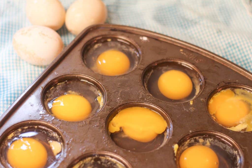 Eggs cracked into a muffin tin to be frozen for later
