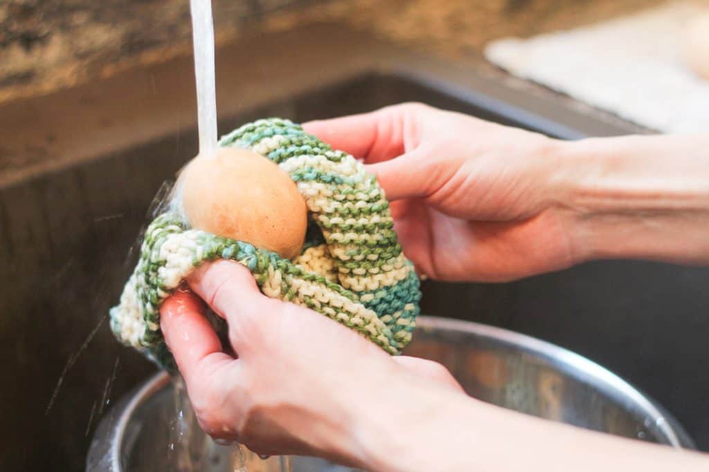 Hands using a rag to wash an egg