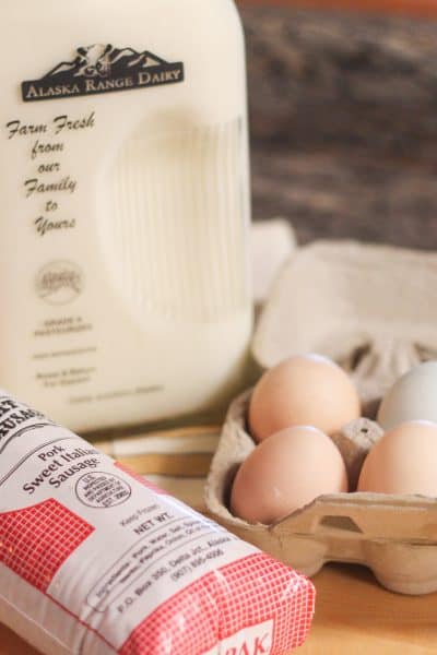 A bottle of local milk, a package of local meat, and a carton of local eggs