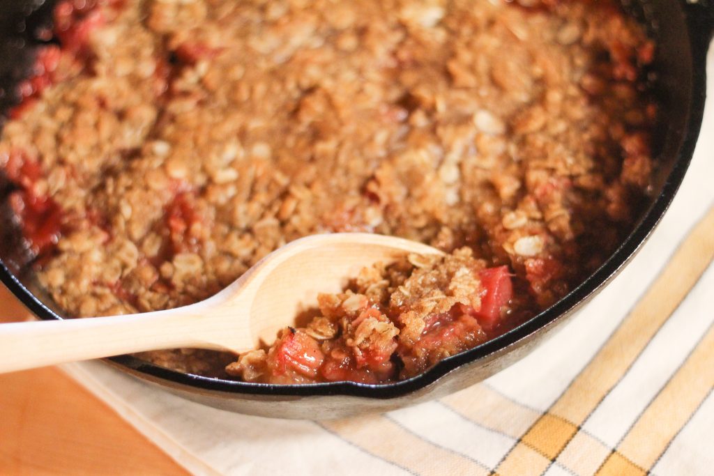 A wooden spoon scooping out rhubarb crisp