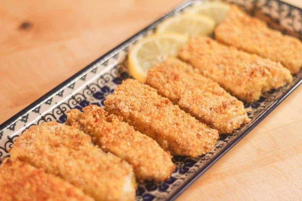 Homemade fish sticks with lemon wedges