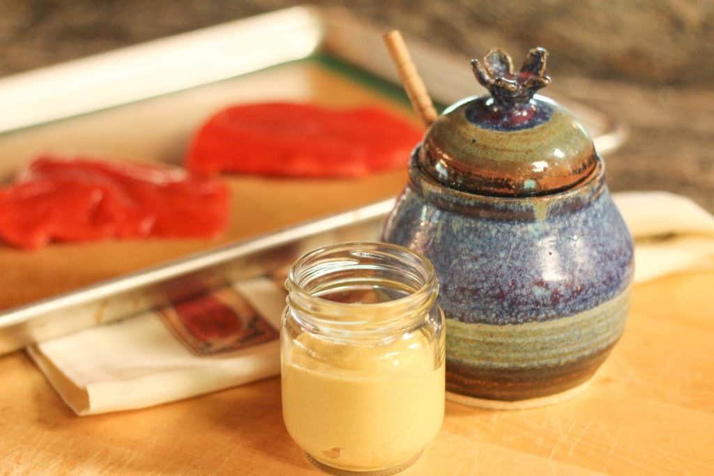 A honey pot and jar of dijon mustard