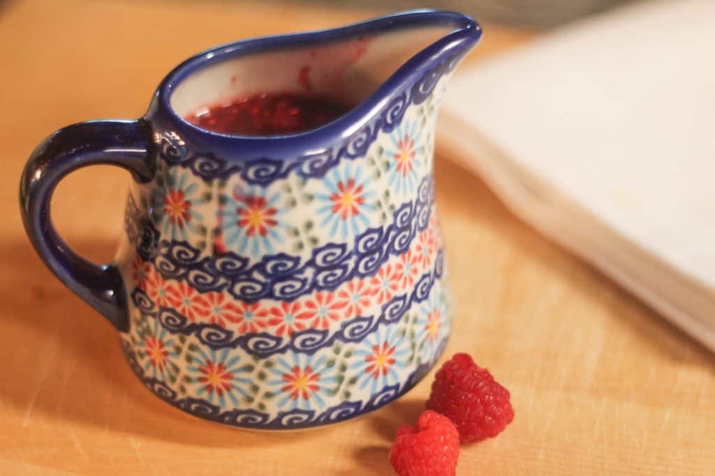 A small pitcher of berry syrup