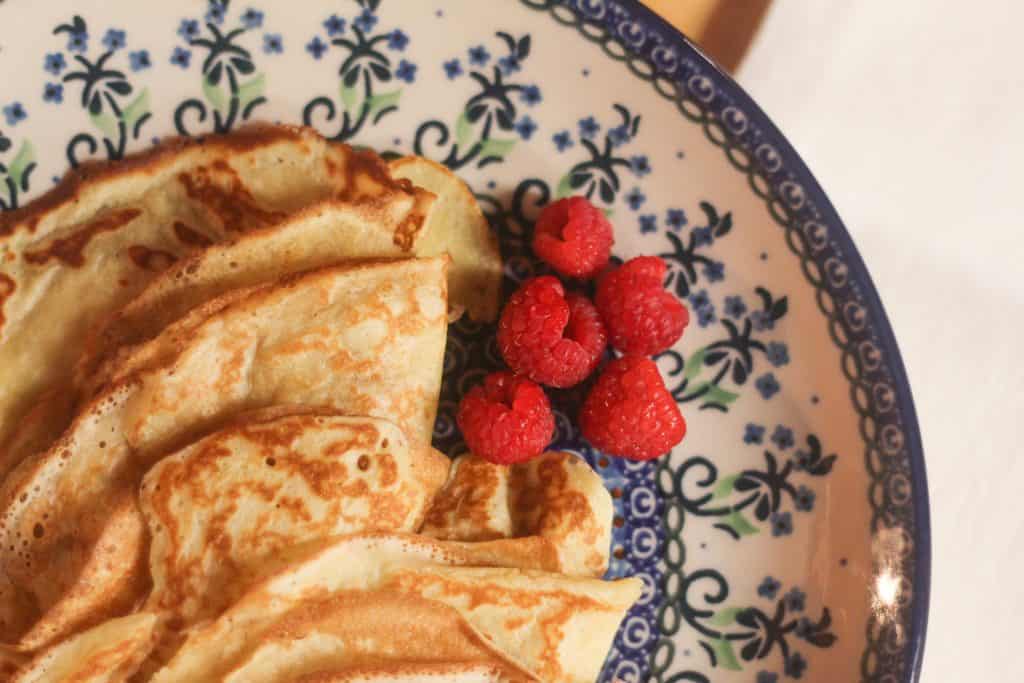 Sourdough crepes on a plate with raspberries