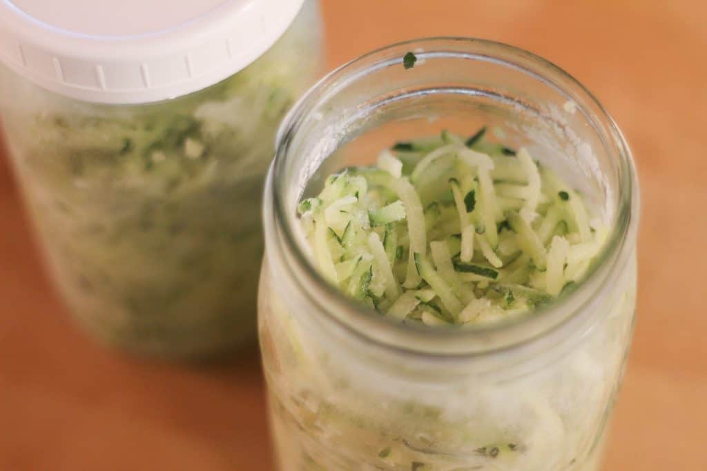 A glass jar of shredded zucchini