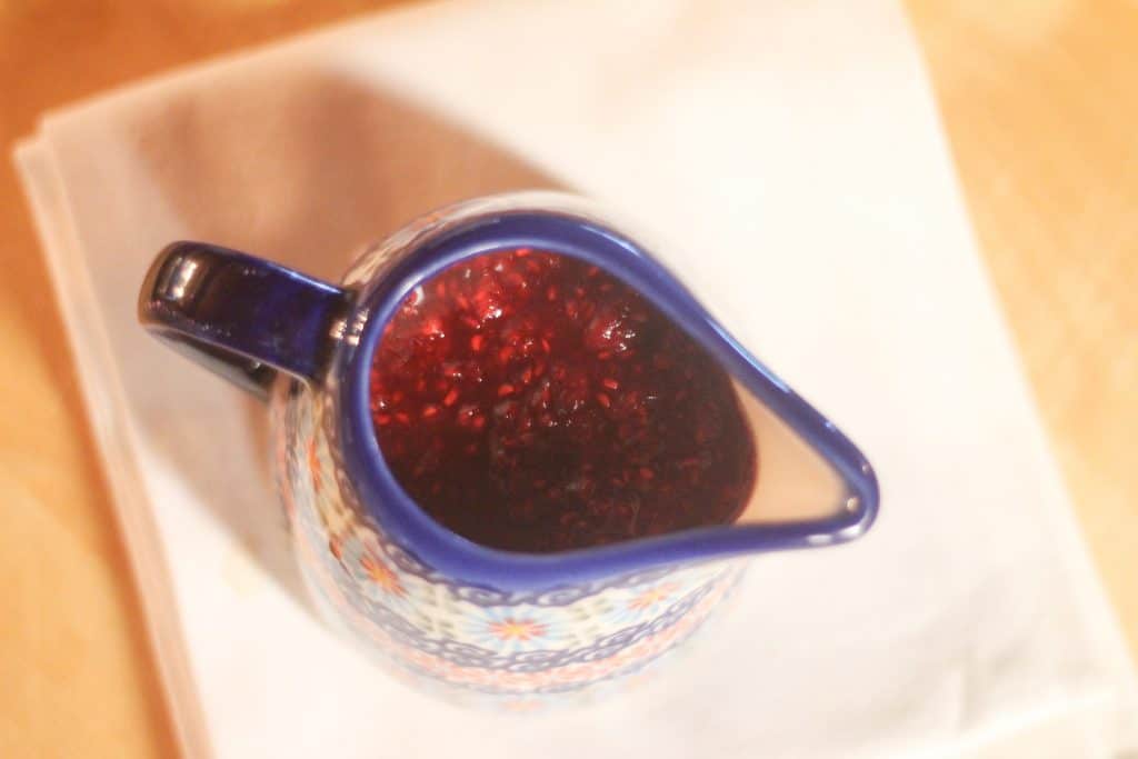Looking into a pitcher of berry sauce