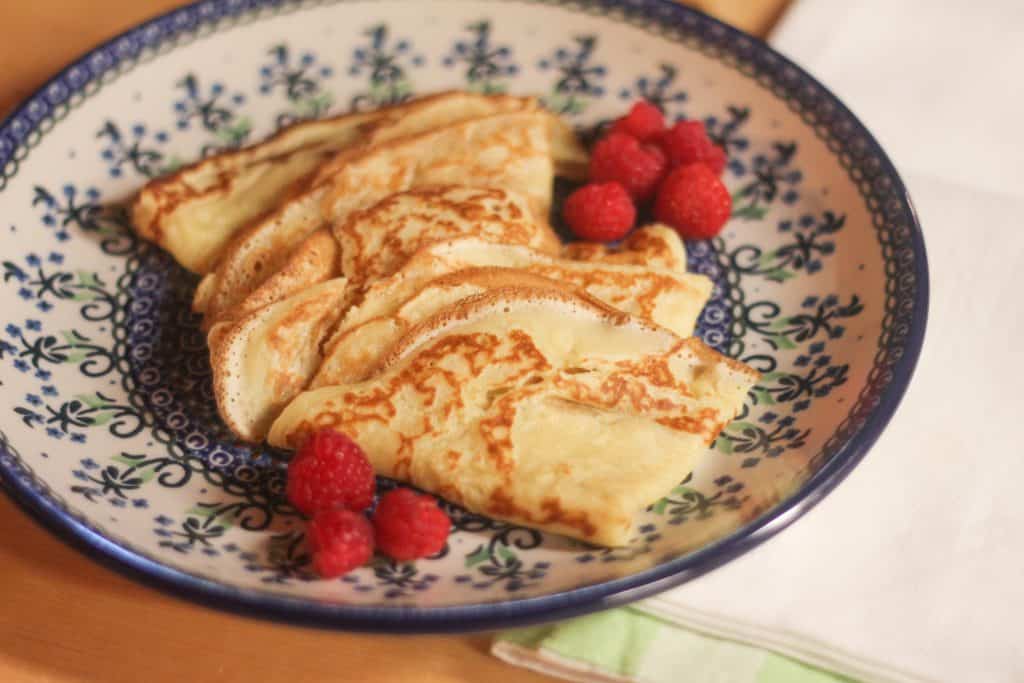 Sourdough crepes on a plate with raspberries