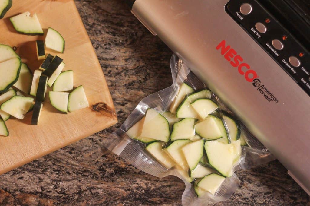 A vacuum sealer and bags of chopped zucchini