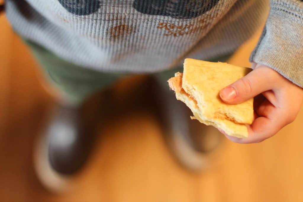A toddler holding a cracker