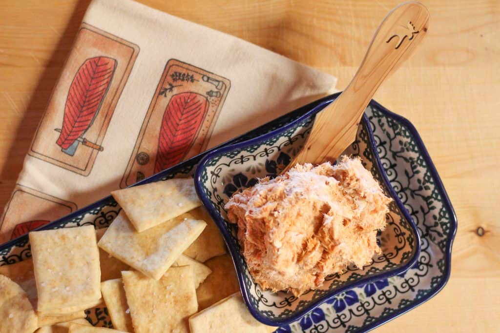 Smoked salmon dip in a pottery dish next to crackers