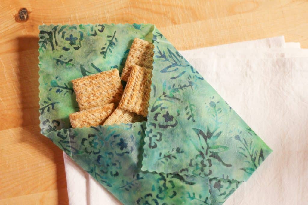 Beeswax wrap folded into an envelope and holding crackers