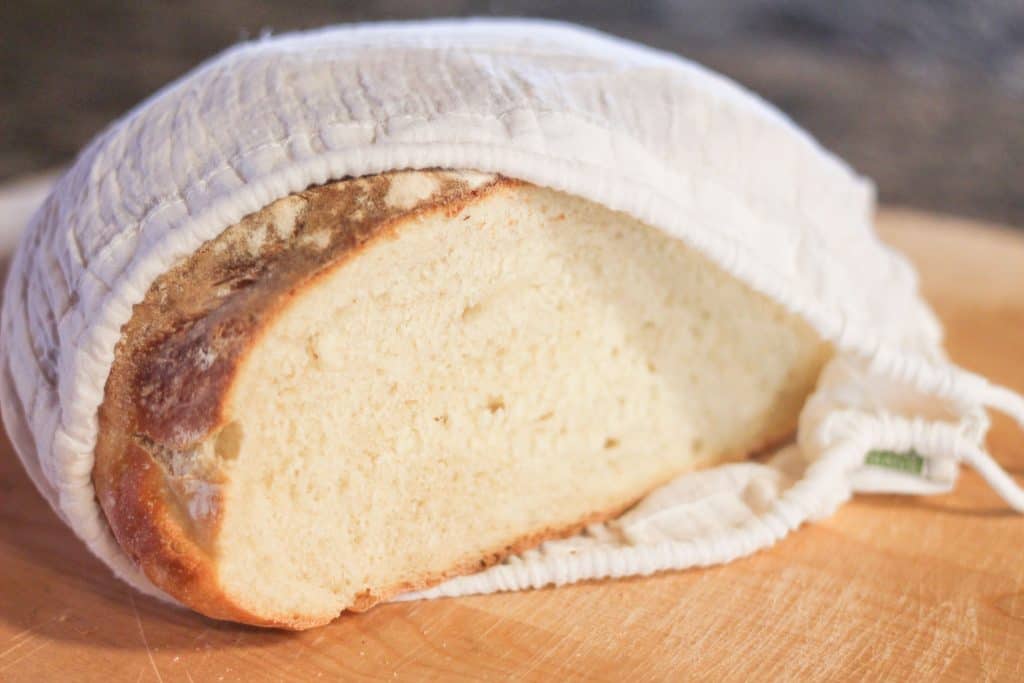 A cut loaf of bread in a linen bread bag-how to store homemade sourdough bread