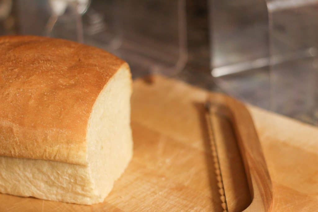 A loaf of sourdough bread sliced with a bread knife