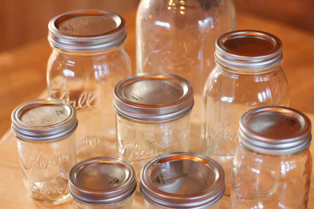 Several glass empty jars showing the sizes of canning jars