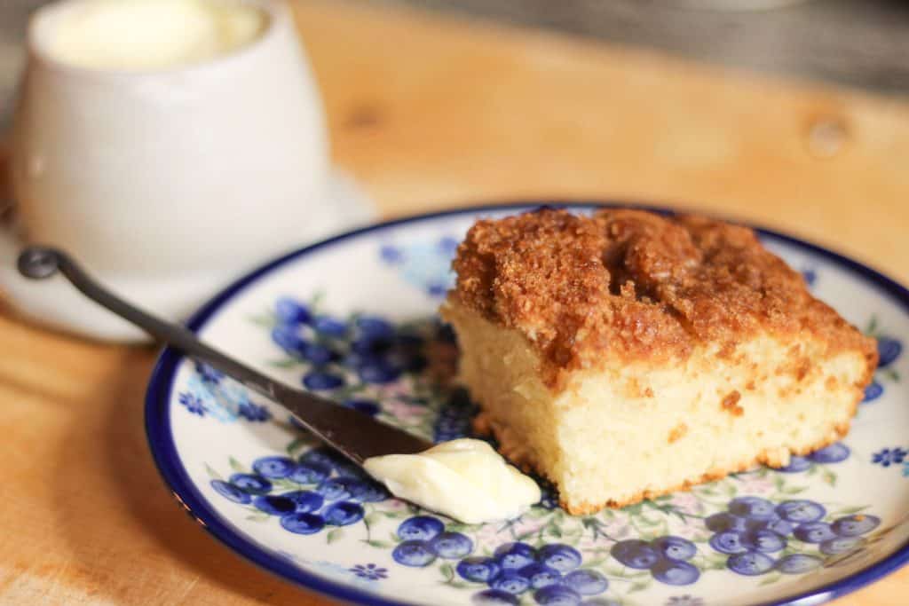 Slice of coffee cake on a plate with a butter knife