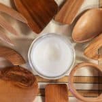 Wooden utensils laying in a circle with a jar of homemade spoon butter in the middle