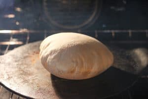 A pita puffed up in an oven