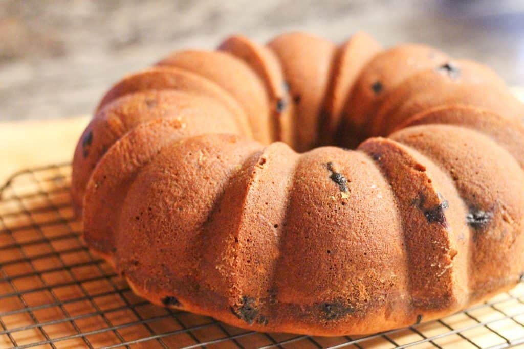 A blueberry bundt cake cooling on a wire rack.