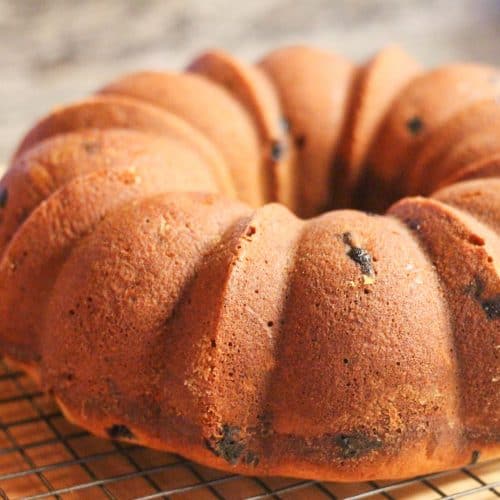 A blueberry bundt cake cooling on a wire rack.