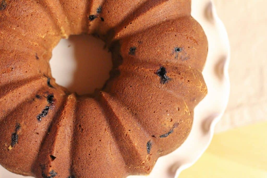 Looking down onto the top of a blueberry bundt cake on a cake stand.