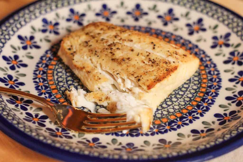 Cooked and flaked halibut on a plate