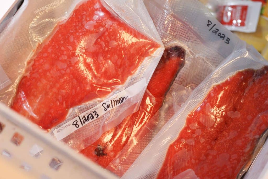 Several packages of frozen salmon in the freezer