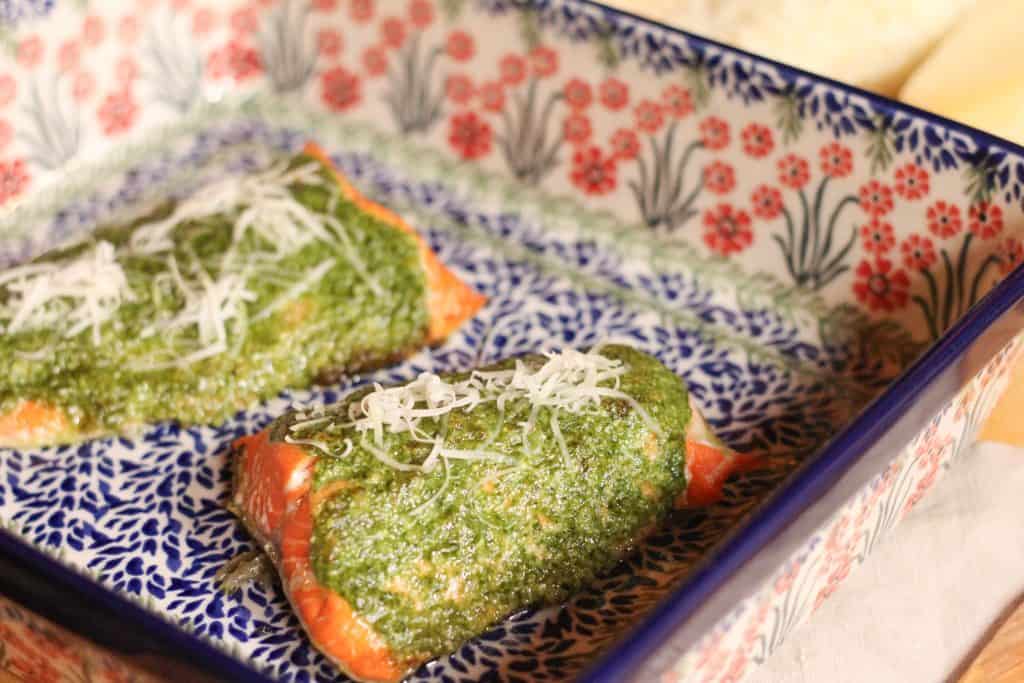 Cooked pesto salmon fillets in a serving dish