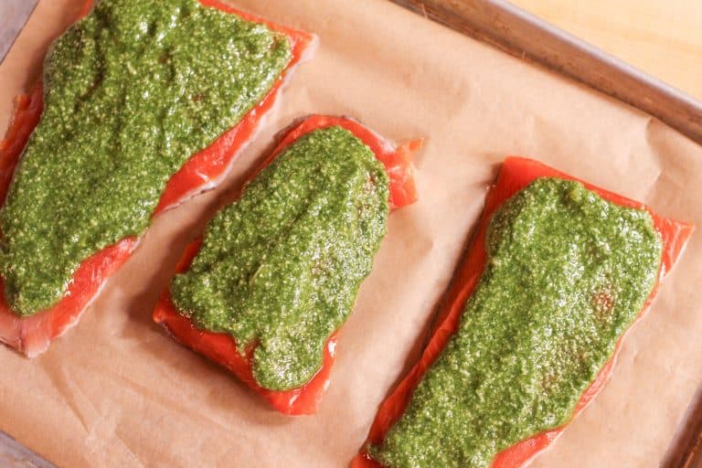 3 salmon fillets with homemade pesto spread on them